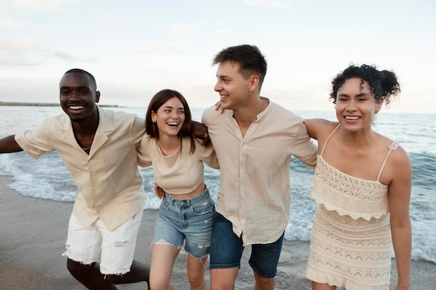 Amigos felices en la playa de tiro medio