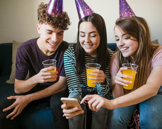 Amigos felices que sostienen tazas de jugo