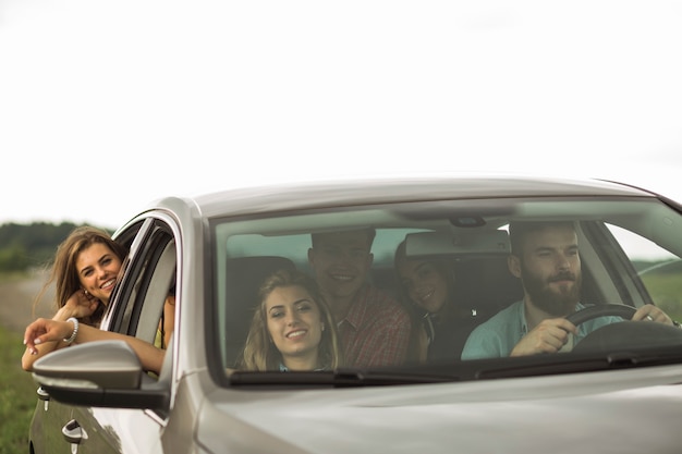 Amigos felices que viajan en coche de lujo