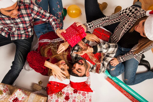 Amigos felices en el suelo con regalos