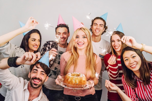 Amigos felices con tarta de cumpleaños