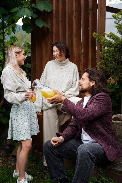 Amigos felices de tiro completo con bebidas al aire libre