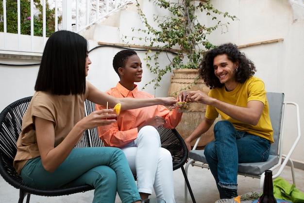 Foto gratuita amigos felices de tiro completo con bebidas