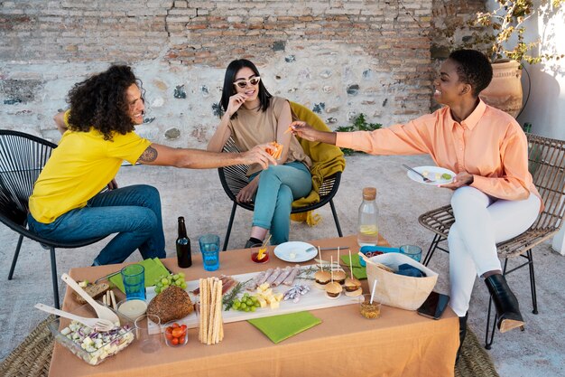 Amigos felices de tiro completo con comida