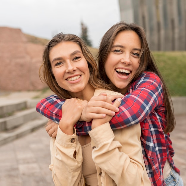 Amigos felices de tiro medio abrazados