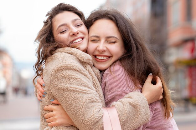 Amigos felices de tiro medio abrazándose