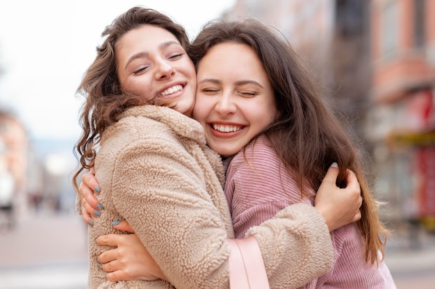 Amigos felices de tiro medio abrazándose