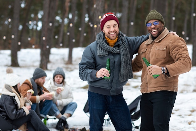 Amigos felices de tiro medio con botellas de cerveza.