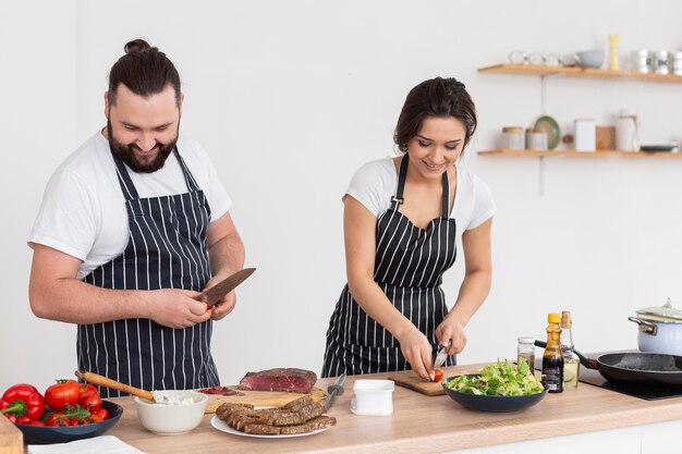 Amigos felices de tiro medio cocinando juntos