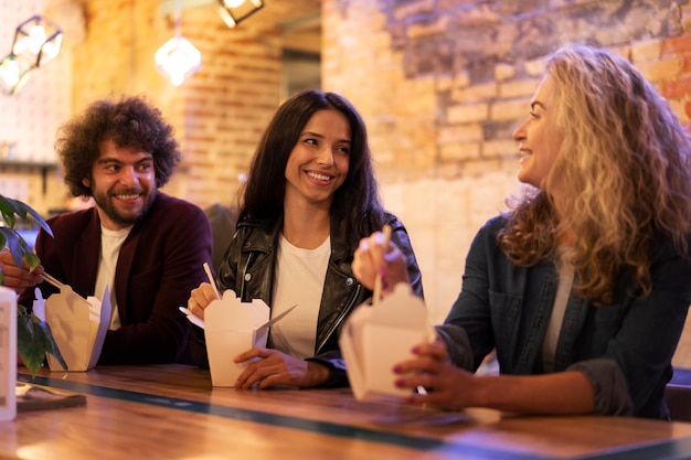 Amigos felices de tiro medio con comida