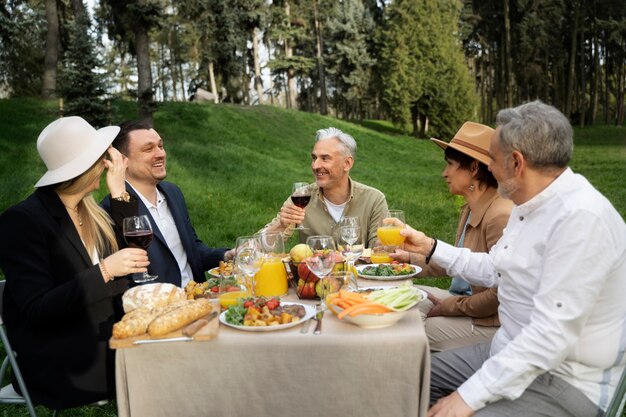 Amigos felices de tiro medio de fiesta en la naturaleza