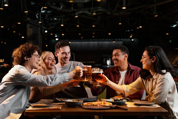 Amigos felices de tiro medio con jarras de cerveza