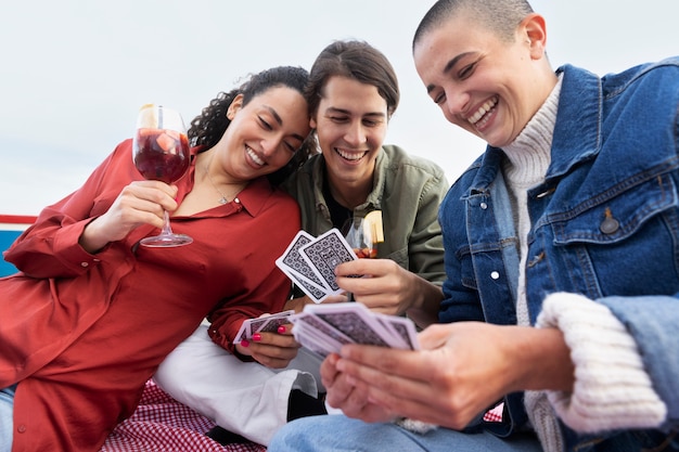 Foto gratuita amigos felices de tiro medio jugando a las cartas