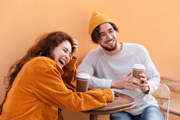 Amigos felices de tiro medio con tazas de café