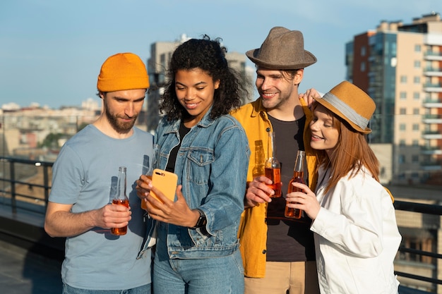 Amigos felices tomando selfie al aire libre tiro medio