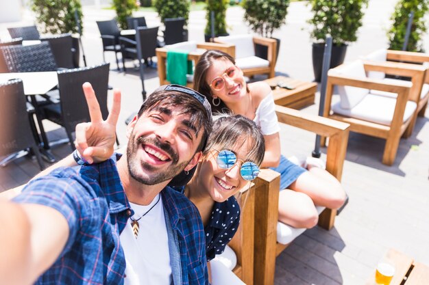 Foto gratuita amigos felices tomando selfie juntos