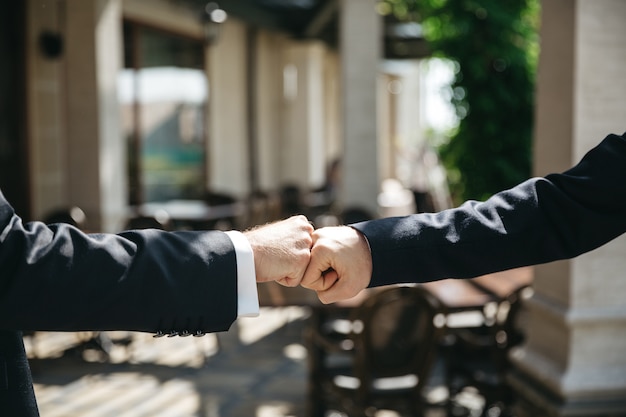 Amigos golpean las manos en la ceremonia de la boda