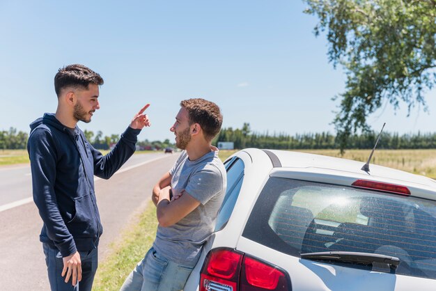 Amigos hablando junto a la carretera