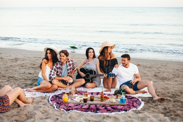 Amigos haciendo una fiesta de playa por la orilla