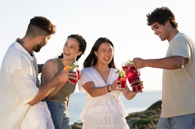 Amigos haciendo una fiesta de sangría en la playa