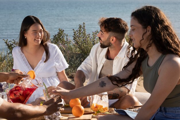 Amigos haciendo una fiesta de sangría en la playa