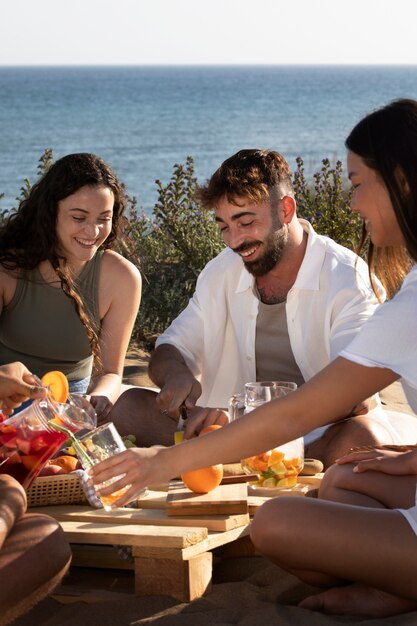 Amigos haciendo una fiesta de sangría en la playa