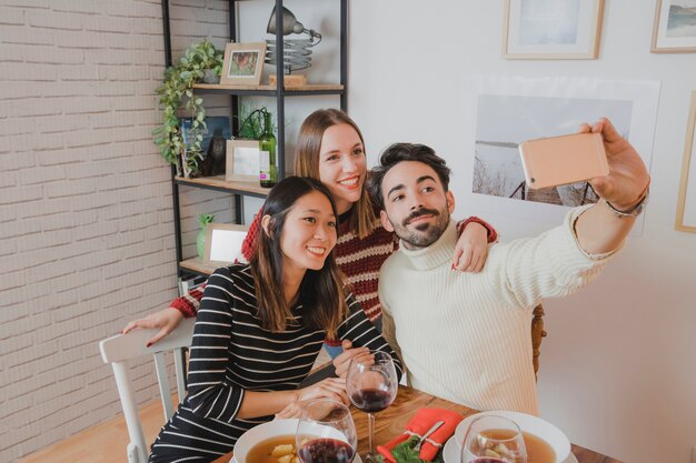 Amigos haciendo selfie en cena de navidad