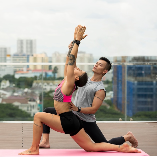 Foto gratuita amigos haciendo yoga juntos al aire libre