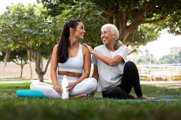 Foto gratuita amigos haciendo yoga juntos en el parque