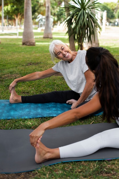 Foto gratuita amigos haciendo yoga juntos en el parque