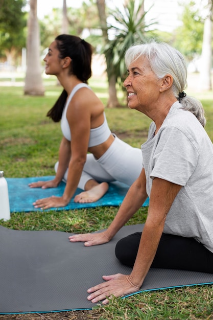 Foto gratuita amigos haciendo yoga juntos en el parque