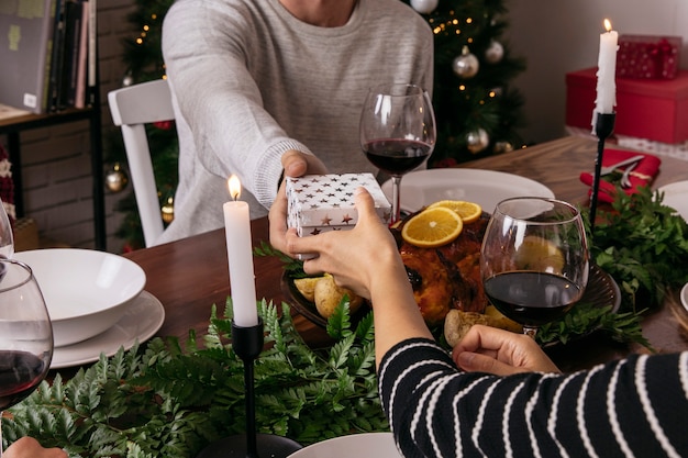 Foto gratuita amigos intercambiando regalo en cena de navidad