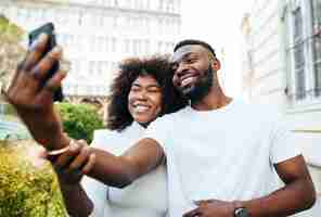 Foto gratuita amigos interculturales al aire libre tomando selfie