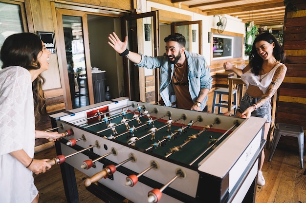 Amigos jóvenes jugando al fútbol de mesa