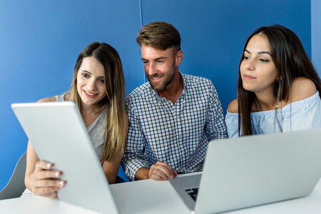 Amigos jóvenes trabajando con dispositivos