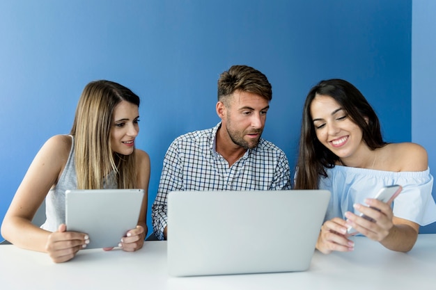 Amigos jóvenes trabajando con dispositivos