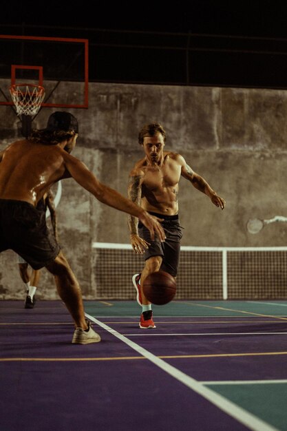 Los amigos juegan al baloncesto. Los jóvenes juegan al baloncesto en la calle.