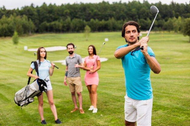 Amigos jugando al golf en campo