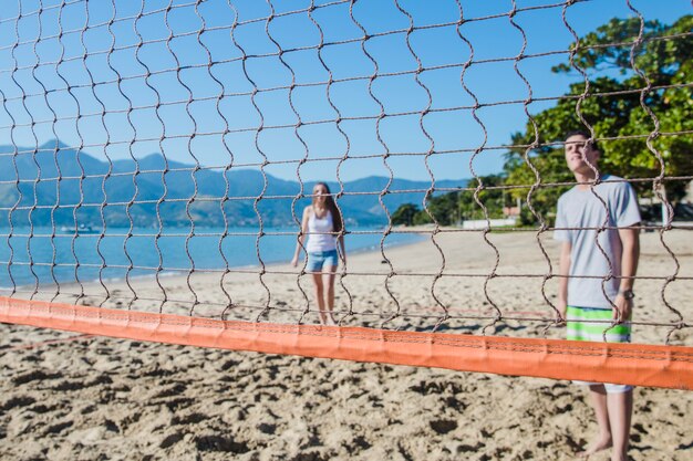 Amigos jugando al voley en playa paradisíaca