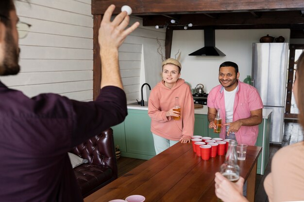 Amigos jugando Beer pong juntos en una fiesta