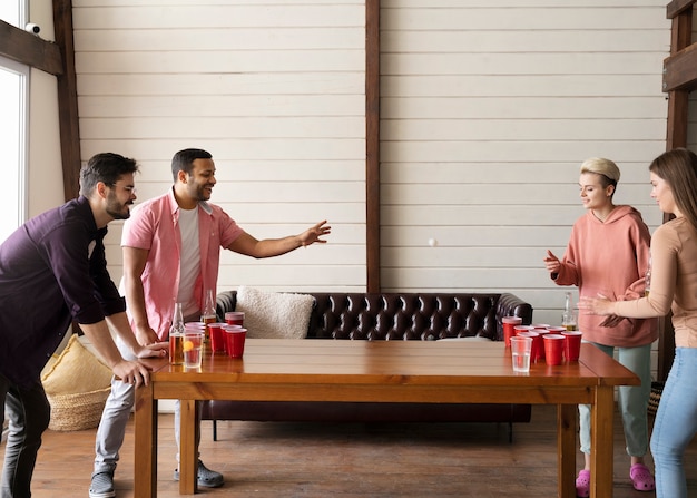 Amigos jugando Beer pong juntos en una fiesta