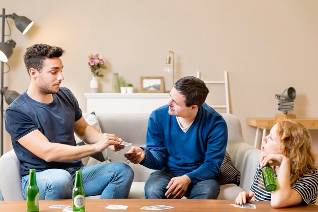 Amigos jugando a las cartas en casa y tomando cerveza