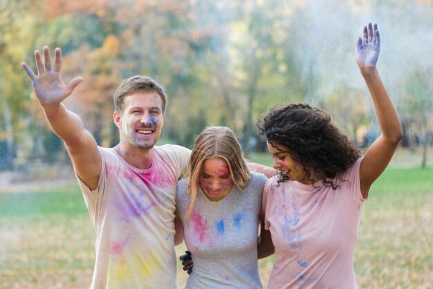 Amigos jugando con pintura de colores en holi