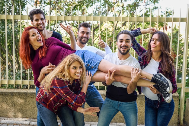 Foto gratuita amigos levantando a una chica en el aire apoyada en todos