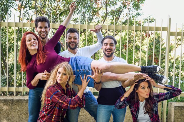 Amigos levantando a una chica en el aire apoyada en todos