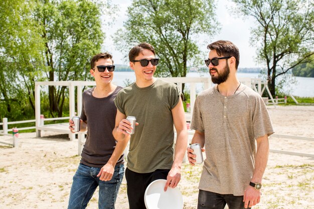 Amigos masculinos alegres bebiendo cerveza