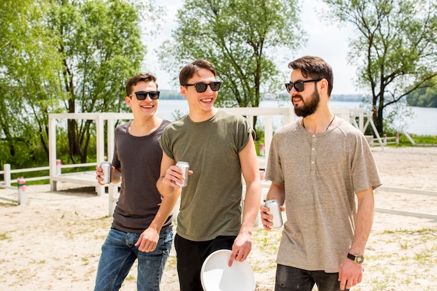 Amigos masculinos alegres bebiendo cerveza