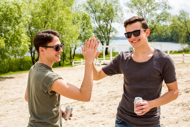 Amigos masculinos alegres dando alta cinco