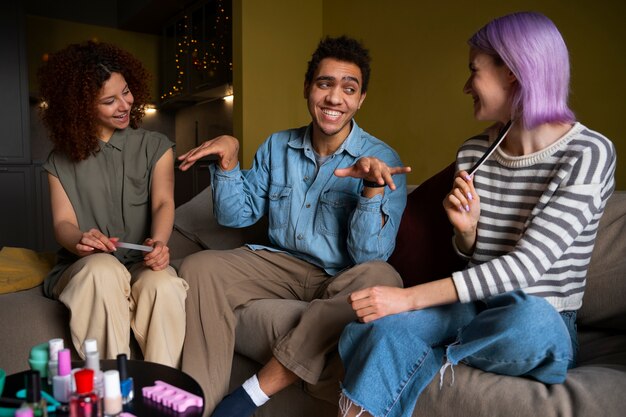 Amigos masculinos y femeninos haciéndose la manicura juntos