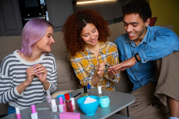 Amigos masculinos y femeninos haciéndose la manicura juntos